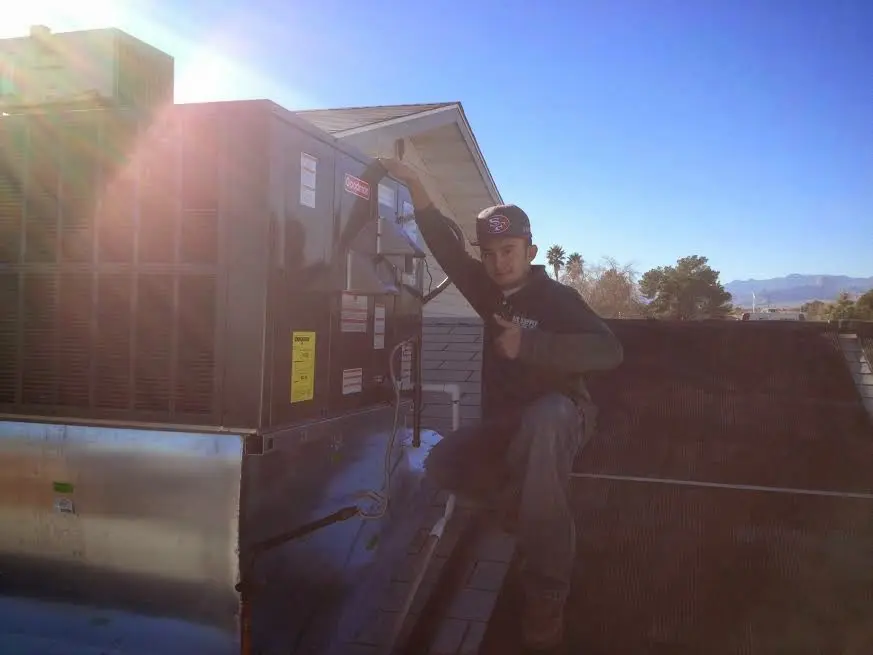 HVAC technician performing Air Duct Cleaning on a rooftop unit in Plainfield